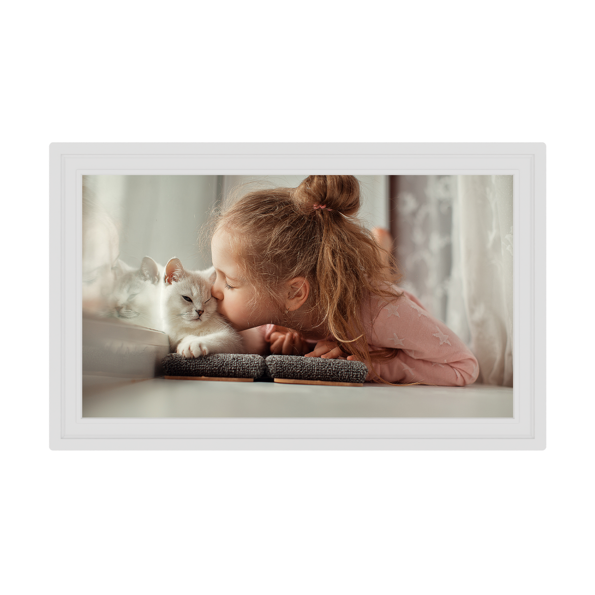 Framed picture of a child and a cat lying on a bed