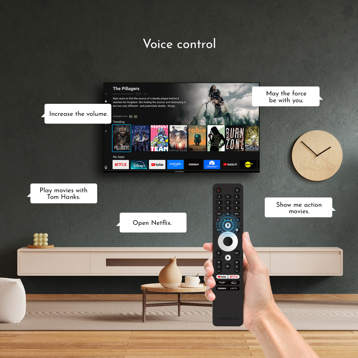 Hand holding a remote control with TV displaying movie options in a living room setting, featuring voice control.